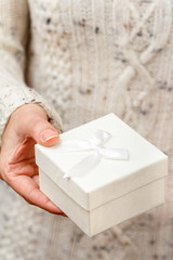 Obraz na płótnie Canvas Woman holding a white gift box in the hand.