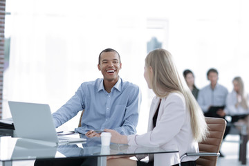 Beautiful young business partners are using a laptop, discussing documents