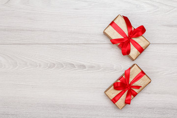 Gift boxes with red ribbons on gray wooden boards.