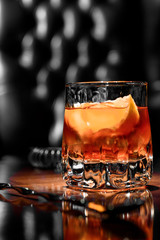 old fashioned cocktail with orange slice, and orange peel garnish
