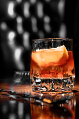 old fashioned cocktail with orange slice, and orange peel garnish