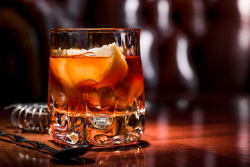 old fashioned cocktail with orange slice, and orange peel garnish