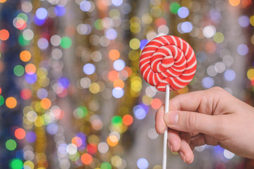 lollipop on a blurred background of Christmas garlands close up