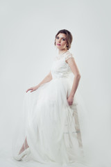 Fototapeta premium Beautiful woman with makeup and bridal hairstyle wearing white dress