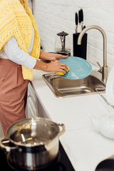 close up of female hands washing dishes at kitchen