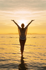 Fototapeta premium Silhouette of a Beautiful Woman at the beach in Thailand at sunset