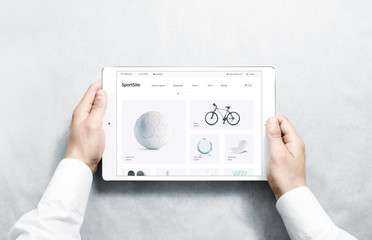 Hands holding tablet with sport webstore mock up on screen