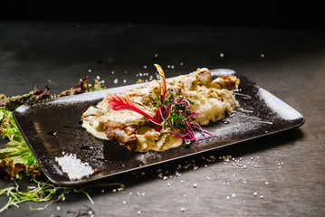 roasted chicken leg under the sauce on black background