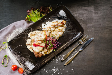 roasted chicken leg under the sauce on black background