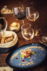 Tartare steak with a glass of wine and hornets, product photography for the restaurant, modern gastronomy