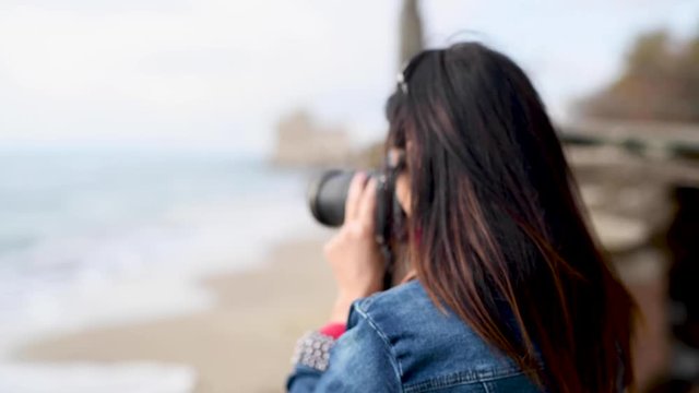 Female photographer on the beach, blurred defocused action