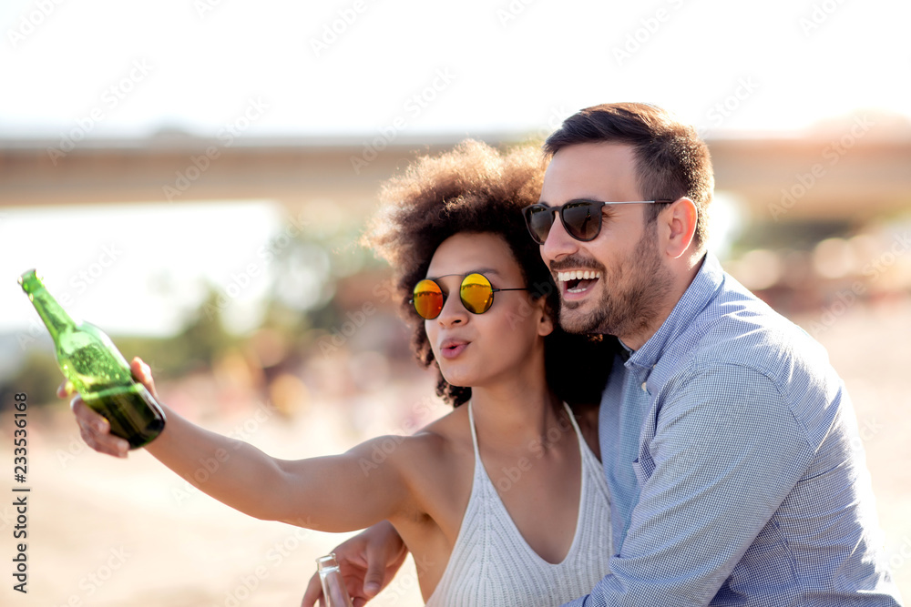 Wall mural Girl and boyfriend laughing on sunny beach