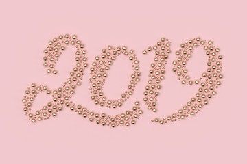 Minimal christmas background composition. 2019 text with scattered gold decoration balls and stars on pastel pink background. 3D rendering.