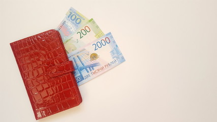 The money for the trip is under the red notebook