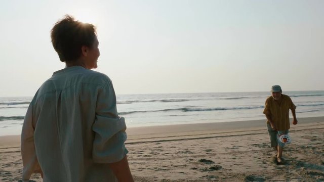 Active senior couple playing tai chi ballon ball at the beach.