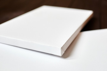 Fototapeta premium Two white blank canvases on brown wooden background. Mockup