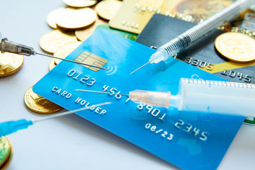 Syringes and credit cards with coins on gray background. The concept of expensive treatment or medical insurance