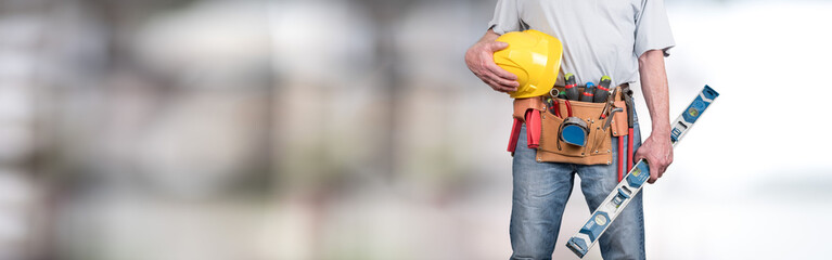 Building worker with tool belt and helmet - obrazy, fototapety, plakaty