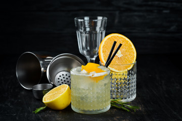 Cocktail Gin tonic with citrus in a glass. On a wooden background. Top view. Free copy space.