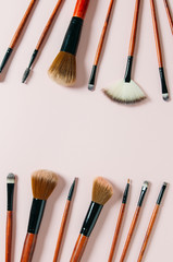 Professional makeup tools brushes on a pastel pink background. magazines, social media. Top view. Flat lay. Copy space
