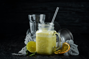Fresh blended cocktail of green apples, kiwi and avocados in a glass cup. On a wooden background....