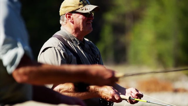 River dingy fly fishing males on freshwater river Wilderness area