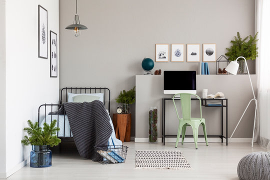 Bright Grey Bedroom Interior With Workspace With Desk And Computer, Real Photo With Copy Space On The Empty Wall