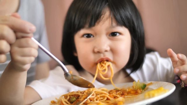 4K Slow motion Happy Asian child eating delicious spaghetti