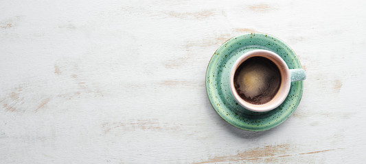 A cup of black coffee on a wooden background. Free space for your text. Top view.