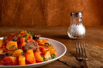 Potatoes stew with sausages and tomato sauce