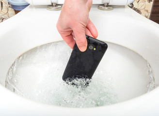 The girl in the bathroom pulls out of the toilet fallen phone.