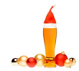 Tall glass of ale or beer with with christmas red hat and baubles on white background