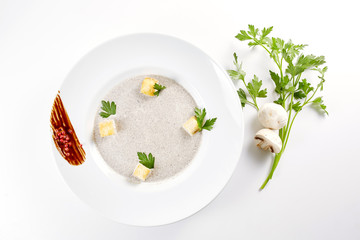 Mushroom cream soup with croutons, herbs and spices over white background close up - homemade vegan vegetarian diet organic meal food soup