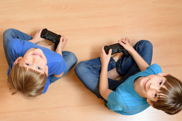 Young brothers playing video game. Flat lay top-down composition