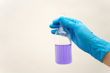 hand in glove holding test tube in the laboratory