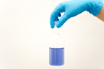 hand in glove holding test tube in the laboratory