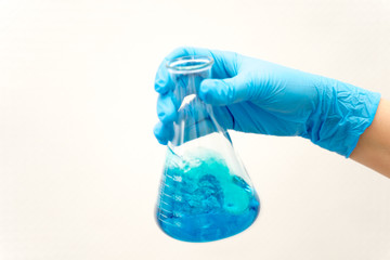 hand in glove holding test tube in the laboratory