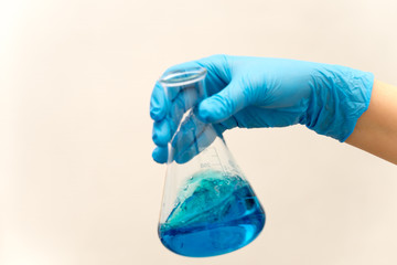 hand in glove holding test tube in the laboratory