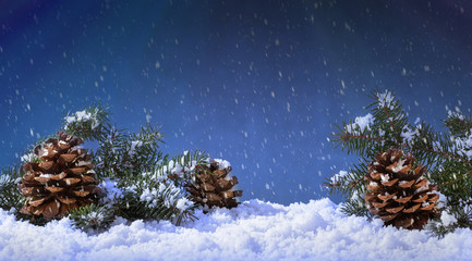 Fototapeta na wymiar Holiday Snowfall onto Pine Cones and Evergreen Tree Branches