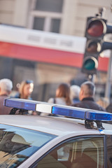 Obraz premium Police car with blue lights on the crime scene in traffic / urban environment.