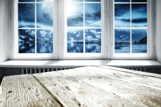 White wooden table with white window and landscape of moon and lake 