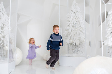 Portrait of happy children, little boy and girl, brother and sister celebrate Christmas. New Year's holidays.