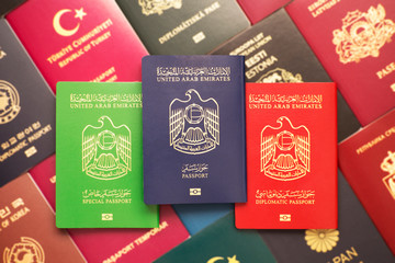 Diplomatic, official and civil passports of the United Arab Emirates against the background of various passports in many countries of the world