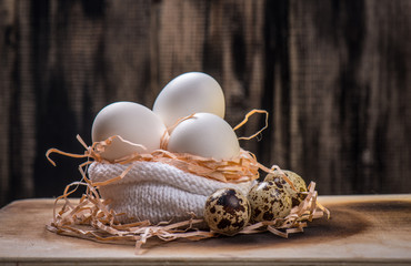 Chicken eggs lie in a knitted bag on a wooden background