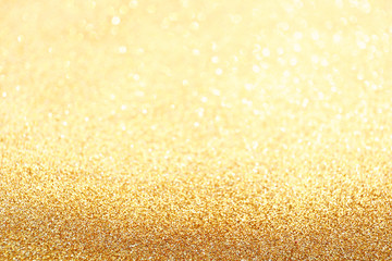 Golden sparkle glitters with bokeh effect and selectieve focus. Festive background with bright gold...