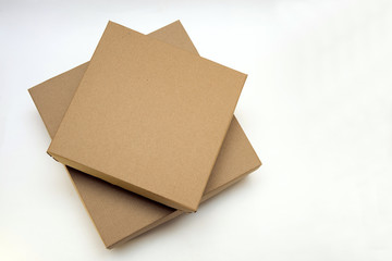 two cardboard boxes lie one on the other on a white background