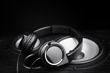 Fototapeta na wymiar Photo of black headphones on music audio speaker. Close-up.