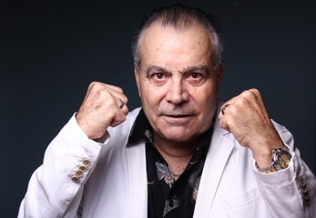 Beautiful older man in front of a colored background