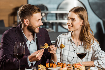 Attractive young adult couple having dinner in restaurant
