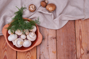 Champignon mushrooms, fresh greens in a ceramic plate. country style